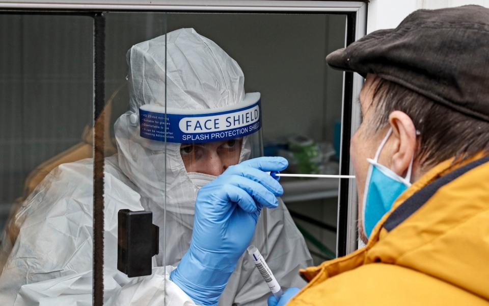 Medical staff takes a COVID-19 test at a coronavirus test center in Cologne, Germany, Thursday, Oct. 15, 2020. The city exceeded the important warning level of 50 new infections per 100,000 inhabitants in seven days. More and more German cities become official high risk corona hotspots with travel restrictions within Germany. (AP Photo/Martin Meissner) - Martin Meissner/AP