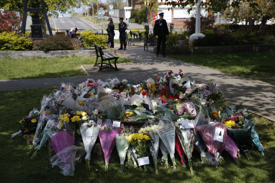 DOVER, ENGLAND - MAY 02: Police officers walk near floral tributes for PCSO Julia James on May 2, 2021 in Aylesham, England.The body of PCSO Julia James, 53, was discovered in the village of Snowdown, near Dover, on Tuesday afternoon. Her Jack Russell dog, Toby, was waiting by her side. So far police have no motive or suspects for her death. She was not in uniform when she was killed. (Photo by Hollie Adams/Getty Images)