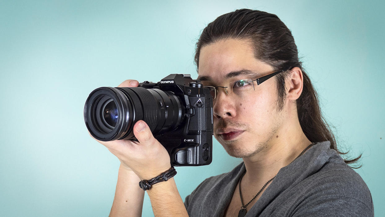  Reviewer James Artaius holding the Olympus M.Zuiko 40-150mm f/2.8 Pro lens, mounted to the Olympus OM-D E-M1X. 