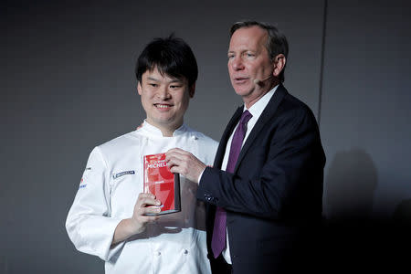 Japanese chef Toshitaka Omiya poses with the Michelin Guide 2017 after been awarded with one Michelin star for the restaurant Alliance, in Paris, France, February 9, 2017. REUTERS/Benoit Tessier