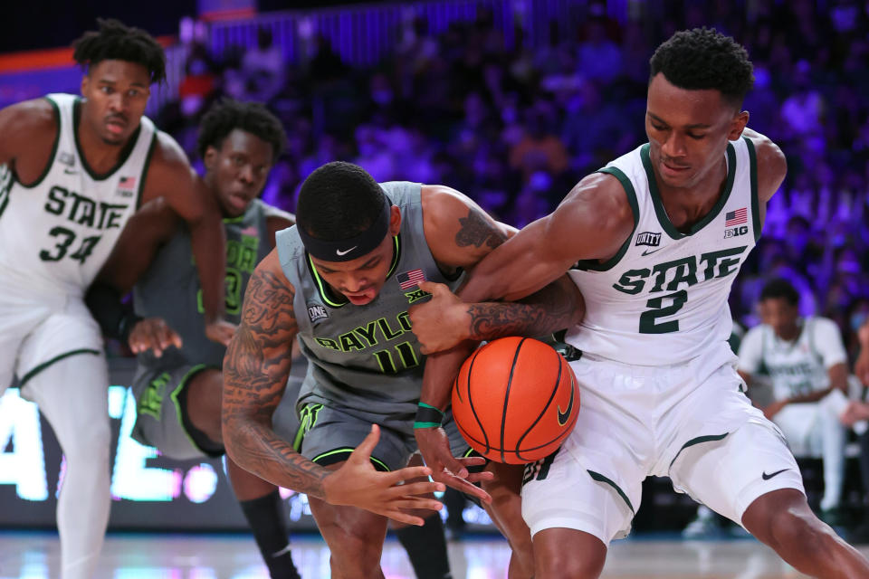 In this photo provided by Bahamas Visual Services, Baylor guard James Akinjo (11) and Michigan State guard Tyson Walker (2) battle for the ball during an NCAA college basketball game at Paradise Island, Bahamas, Friday, Nov. 26, 2021. (Tim Aylen/Bahamas Visual Services via AP)