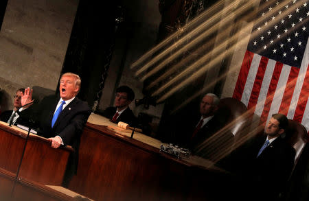 U.S. President Donald Trump and Vice President Mike Pence are seen behind the reflection of a House chamber railing as Trump delivers his State of the Union address to a joint session of the U.S. Congress on Capitol Hill in Washington, U.S., January 30, 2018. Reuters photographer Carlos Barria: "The State of the Union speech is one of the most important political events at the beginning of the year. We usually photograph it from several fixed positions, but this year I was assigned to be the 'rotating' photographer, meaning I could move around on the balcony and shoot from different angles, but only during short windows of time. During one of those windows, I found an interesting play of light reflected off a gold-colored railing, which, at a certain angle, could be seen to fall over the president." REUTERS/Carlos Barria