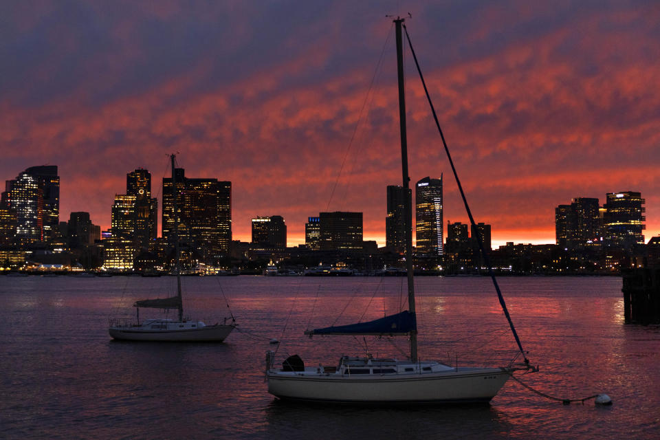 The sun sets behind the city skyline in advance of Hurricane Lee, Friday, Sept. 15, 2023, in Boston. (AP Photo/Michael Dwyer)