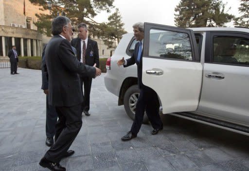 US Secretary of State John Kerry (R) is greeted by Afghan Foreign Minister Zalmai Rassoul (L) on his arrival prior to a meeting with Afghan President Hamid Karzai at the Presidential Palace in Kabul on March 25, 2013