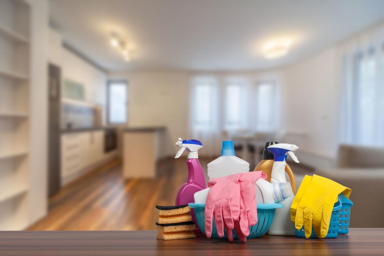 cleaning supplies in foreground, apartment rental in background