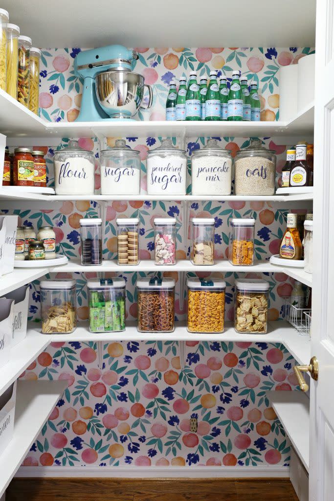 pantry organization ideas, decorative stickers on glass jars full of food in the wallpapered pantry