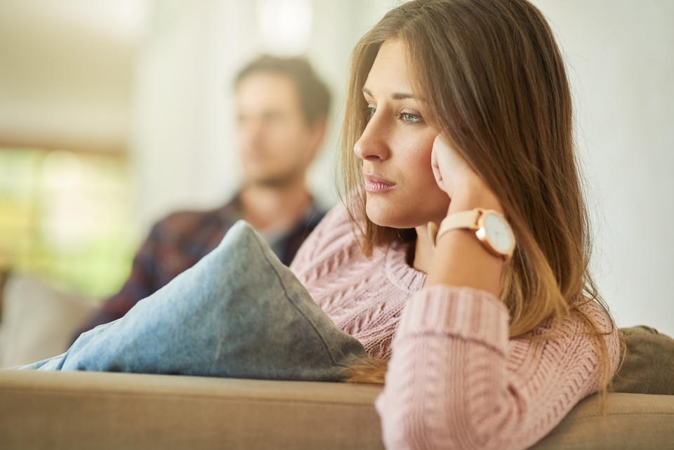 Shot of an unhappy couple sitting on the couch at home after a fight