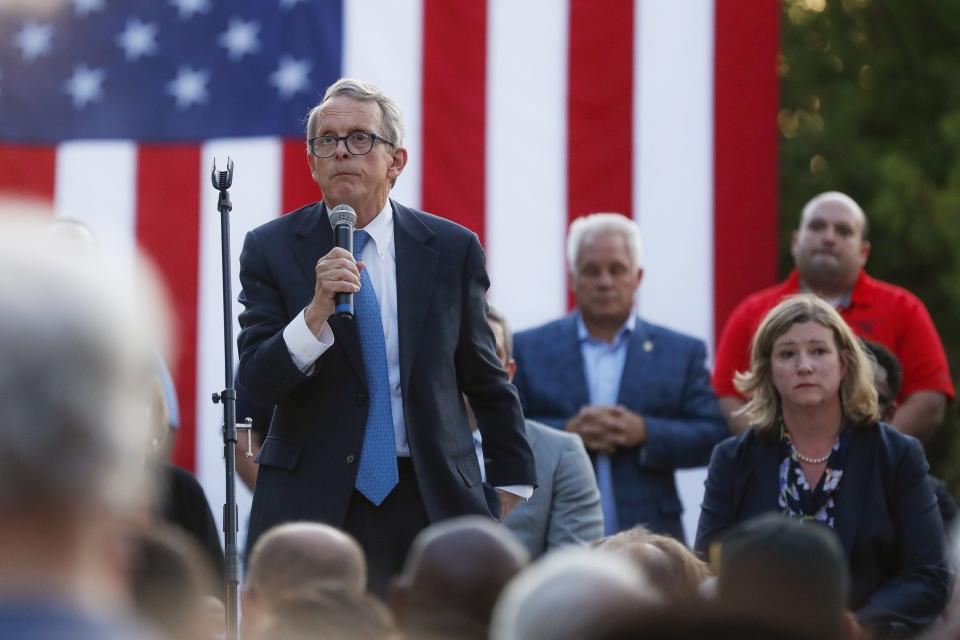 Ohio Gov. Mike DeWine, left, speaks alongside Dayton Mayor Nan Whaley, right, during a vigil at the scene of a mass shooting on Aug. 4, 2019, in Dayton. The legislature blocked a set of tougher gun laws — including a background check provision — proposed by DeWine after the shooting killed nine and wounded 27.