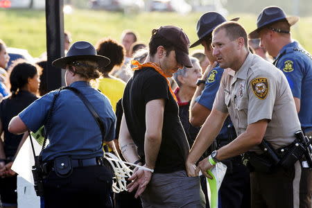 Officers from the St Louis County Police Department and the Missouri Highway Patrol process demonstrators from the "Black Lives Matter" movement who had been arrested for protesting on Interstate 70 in Earth City, Missouri, August 10, 2015. REUTERS/Lucas Jackson