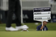 A scorekeeper walks by Tiger Woods at the green on the 17th hole during the third round of the PGA Championship golf tournament at Southern Hills Country Club, Saturday, May 21, 2022, in Tulsa, Okla. (AP Photo/Eric Gay)