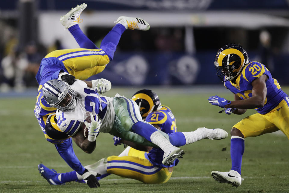 Ezekiel Elliott is tackled by a group of Rams in Saturday’s divisional round playoff game. (AP)