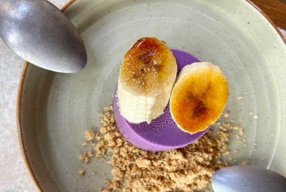 The Wolf's Ube Cheesecake is topped with bruleed bananas and served with brown butter streusel on the side.