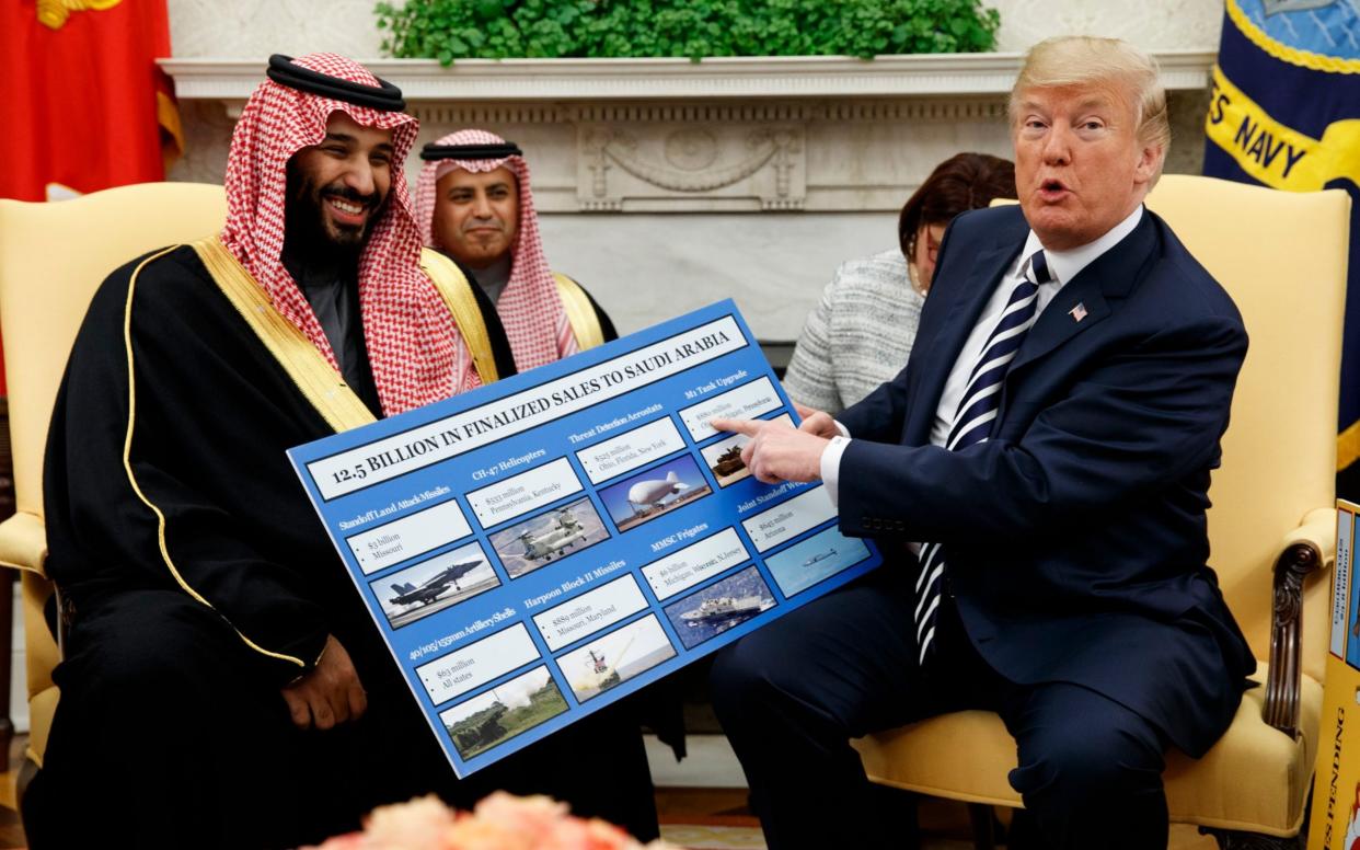 President Donald Trump shows a chart highlighting arms sales to Saudi Arabia during a meeting with Saudi Crown Prince Mohammed bin Salman in the Oval Office of the White House in Washington. - AP