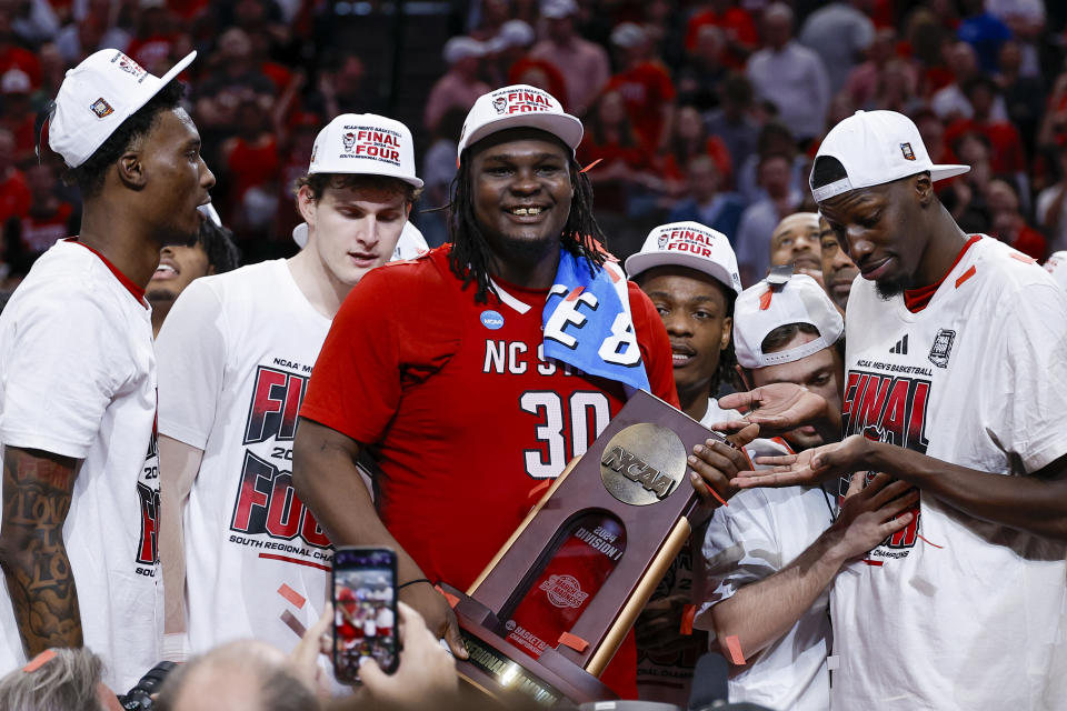 North Carolina State's DJ Burns Jr. holds the South Regional trophy following an Elite Eight college basketball game against Duke in the NCAA Tournament in Dallas, Sunday, March 31, 2024. North Carolina State won 76-64. (AP Photo/Brandon Wade)