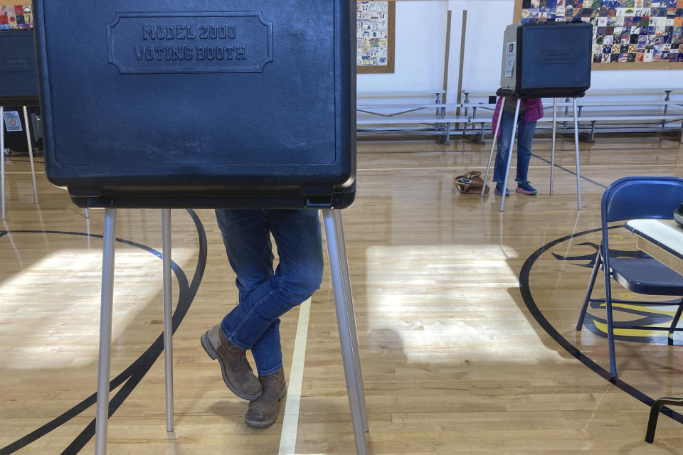 Voters fill out ballots at an elementary school in Tesuque, N.M., on Tuesday, Nov. 8, 2022. New Mexico voters are confronting stark choices as they fill a long list of statewide elected positions for the first time since the coronavirus overwhelmed rural hospitals and sent shockwaves through the economy, public schools and the criminal justice system. (AP Photo/Morgan Lee)