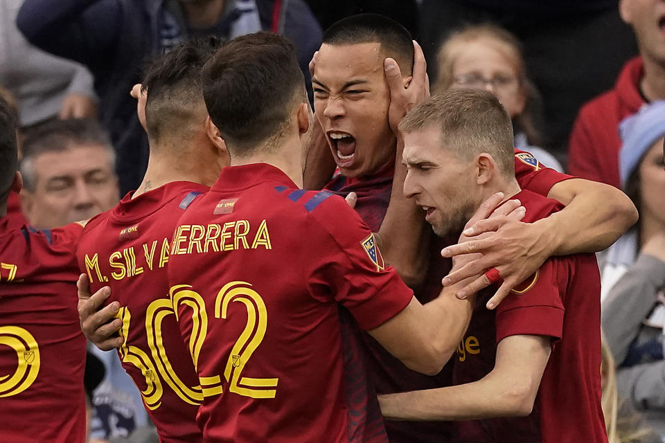 Real Salt Lake forward Bobby Wood, center, celebrates with teammates after scoring the winning goal during the second half of an MLS soccer match against Sporting Kansas City Sunday, Nov. 28, 2021, in Kansas City, Kan. Real Salt Lake won 2-1.(AP Photo/Charlie Riedel)