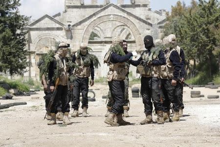 Rebel fighters from 'the First Regiment', part of the Free Syrian Army, chat with each other as they participate in a military training in the western countryside of Aleppo May 4, 2015. REUTERS/Hosam Katan