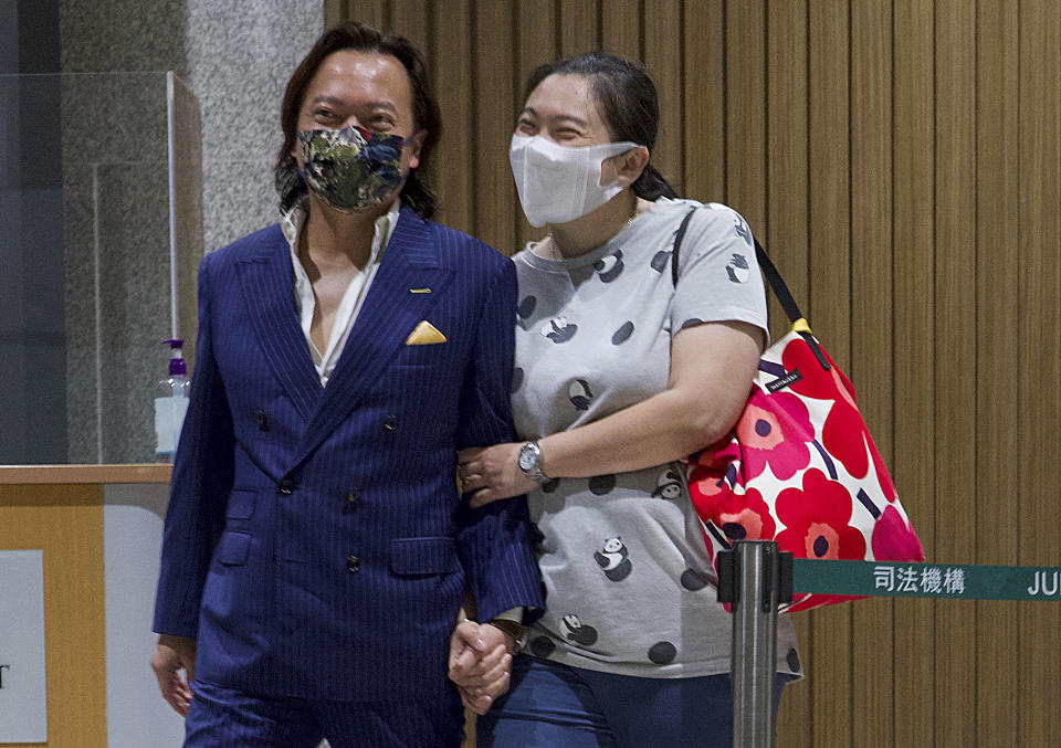 Lawrence Lau, left, one of the 47 pro-democracy activists charged with conspiracy, leaves with his relative after being released on bail outside a court after released in Hong Kong, Friday, March 5, 2021. Four of the 47 pro-democracy activists charged with conspiracy to commit subversion were released on bail Friday, after prosecutors dropped an appeal against the court's decision to grant them bail. (AP Photo/Vincent Yu)