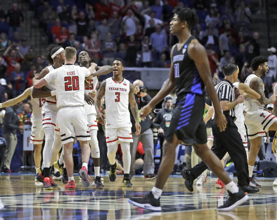 Members of Texas Tech celebrate as Buffalo's Jeenathan Williams walks past in the foreground at the end of a second round men's college basketball game in the NCAA Tournament Sunday, March 24, 2019, in Tulsa, Okla. Texas Tech won 78-58. (AP Photo/Jeff Roberson)