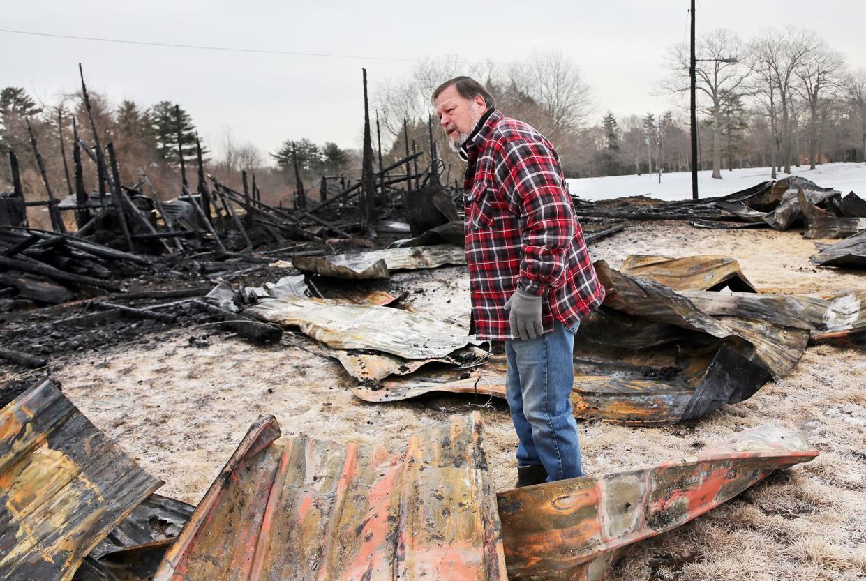 Granite State Fair board member Tom Dubois looks at what is left of a barn which once held horses at the fairgrounds in Rochester March 1, 2022 following a fire Monday night.