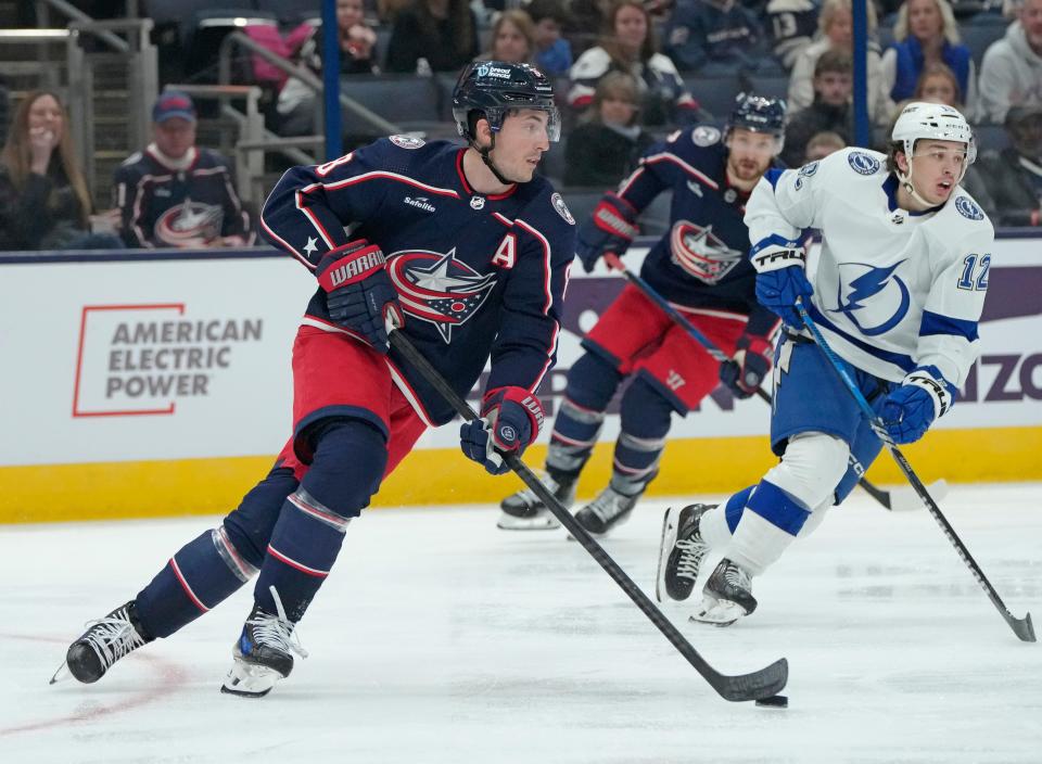 Feb. 10, 2024; Columbus, Ohio, USA; 
Columbus Blue Jackets defenseman Zach Werenski (8) takes the puck up the ice while defended by Tampa Bay Lightning center Alex Barre-Boulet (12) during the second period of a hockey game at Nationwide Arena on Saturday.