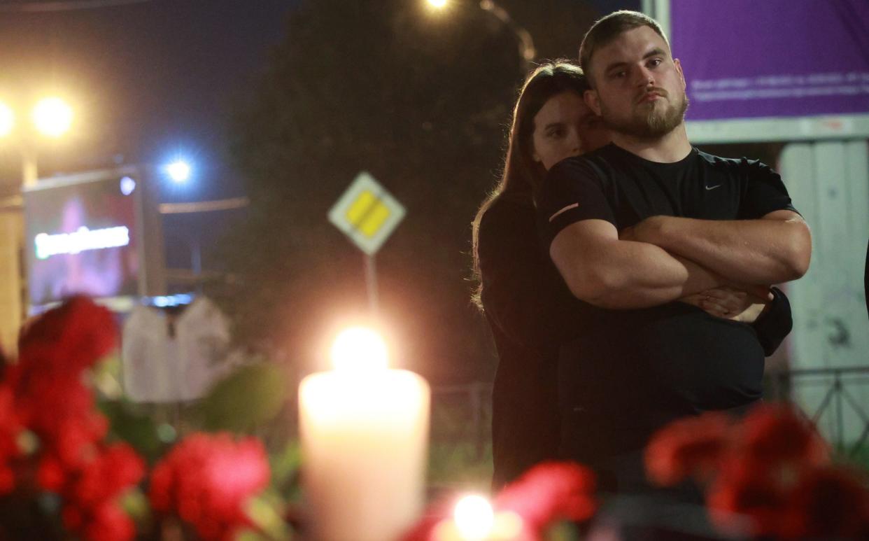 People lay flowers and light candles for Yevgeny Prigozhin at the memorial in front of the 'PMC Wagner Centre' in Saint Petersburg, Russia