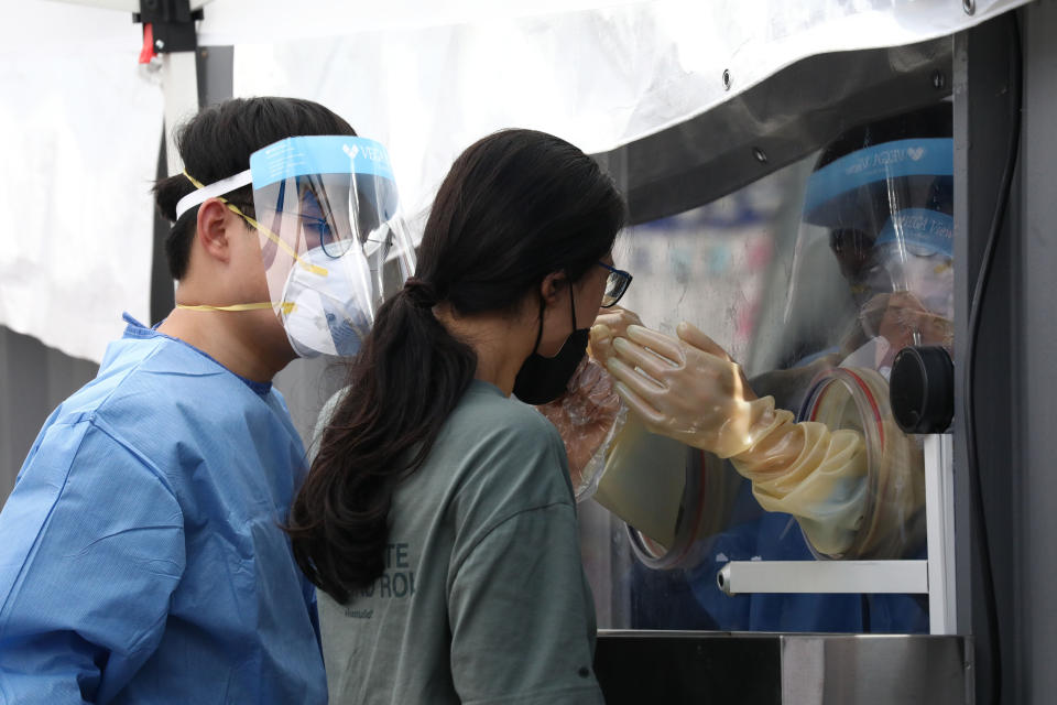 A medical worker takes samples from a woman during the COVID-19 testing at a temporary test facility on Aug. 26 in Seoul, South Korea. Anyone who has symptoms in <strong>Korea,</strong> or who may have contacted a person confirmed to have the virus, regardless of symptoms, can get tested. (Photo: Chung Sung-Jun via Getty Images)