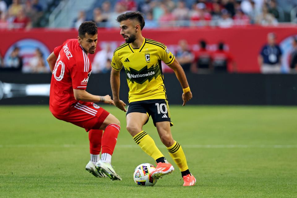 May 18, 2024; Chicago, Illinois, USA; Columbus Crew forward Diego Rossi (10) moves the all against Chicago Fire FC midfielder Gaston Gimenez (30) during the first half at Soldier Field. Mandatory Credit: Mike Dinovo-USA TODAY Sports
