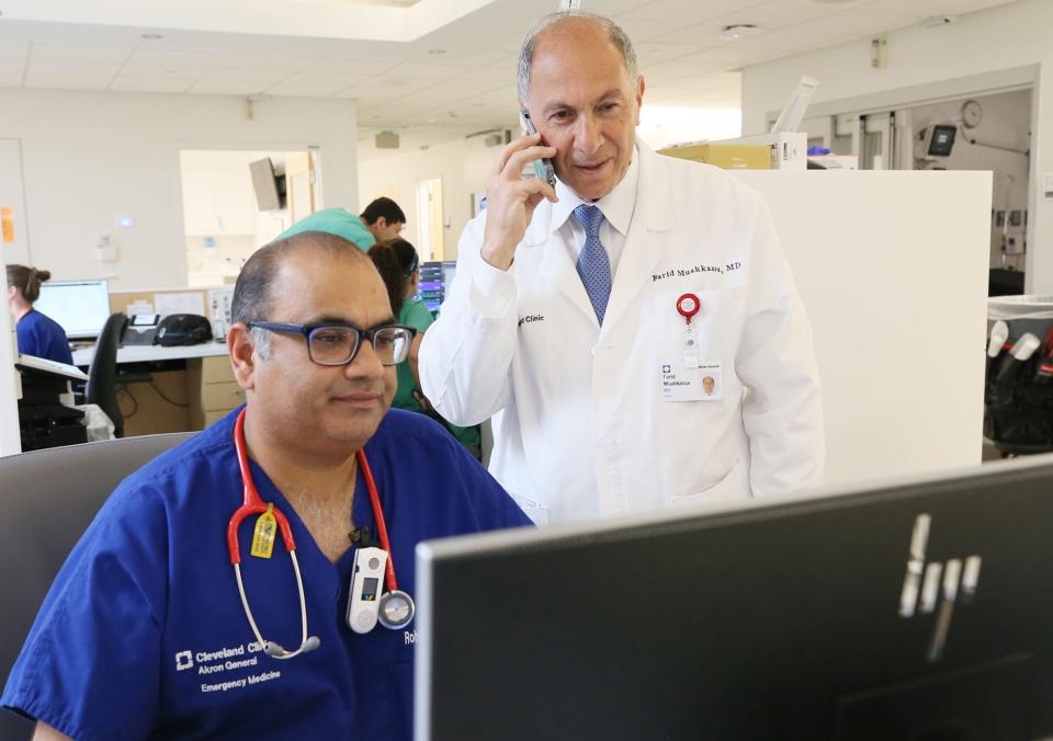 Dr. Rohit Chandurkar confers with Dr. Farid Muakkassa, head of trauma in the Cleveland Clinic Akron General Emergency Department.