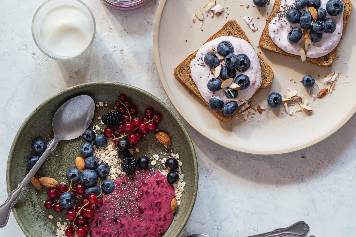 Toasts with cream cheese, fresh blueberries gut health and smothie bowl with rolled oats, fresh berries served with kefir, healthy breakfast or brunch, table top view
