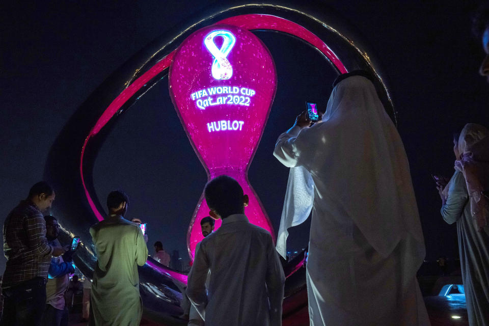 FILE - People take photos with the official FIFA World Cup Countdown Clock on Doha's corniche, in Qatar, Friday, Oct. 14, 2022. A recent outpouring of local anger to scenes of foreign artists and models reveling in Qatar underscored the tensions tearing at the conservative Muslim emirate. (AP Photo/Nariman El-Mofty, File)