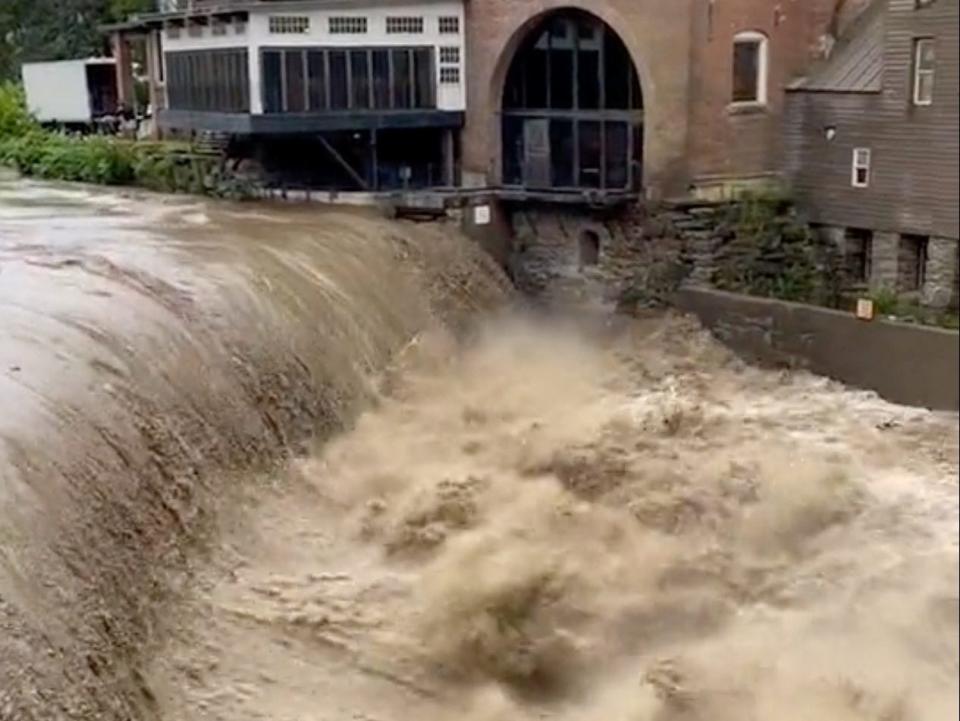 Floodwaters pour over the dam on the Ottauquechee River, in Quechee, Vermont, U.S. in this screen grab obtained from a social media video released on July 10, 2023.