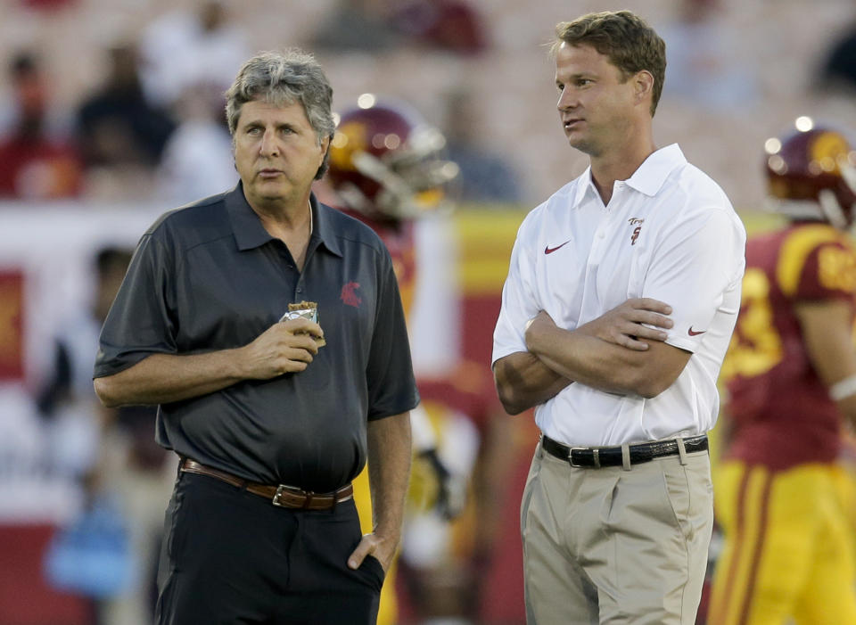 Then-Southern California coach Lane Kiffin (R) and then-Washington State coach Mike Leach watch their teams warm up for an NCAA college football game in Los Angeles, Saturday, Sept. 7, 2013. (AP Photo/Chris Carlson)