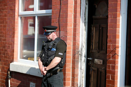 A police officer stand outside a property in Moss Side, following overnight raids in Manchester, Britain May 25, 2017. REUTERS/Andrew Yates