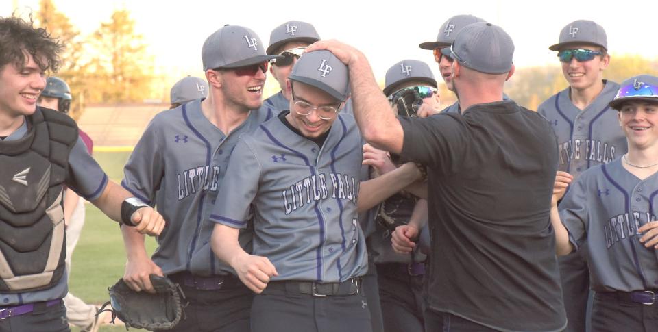 Teammates swarm Little Falls Mountie Gavin Trumbull (center) Tuesday following the final out of his perfect game against Sherburne-Earlville.