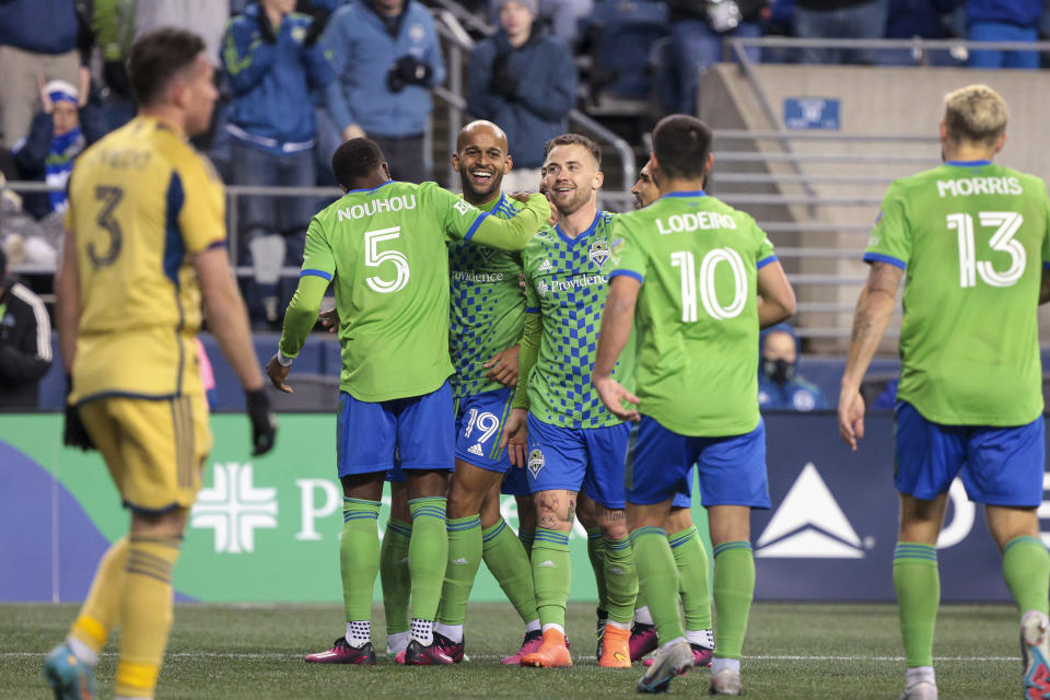 Seattle Sounders forward Heber, second from left at rear, celebrates his goal with Nouhou Tolo (5), Albert Rusnak, and Nicolas Lodeiro (10) as Real Salt Lake defender Bryan Oviedo (3) walks in the foreground during the second half of an MLS soccer match Saturday, March 4, 2023, in Seattle. The Sounders won 2-0. (AP Photo/Jason Redmond)