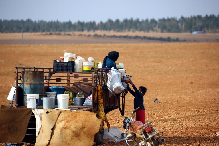 Displaced Syrians, who fled their hometowns due to clashes between regime forces and the Islamic State (IS) group, prepare food in Kharufiyah, 18 kilometres south of Manbij, on March 4, 2017