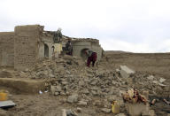 Afghan villagers remove bricks after their home was damaged by Monday's earthquake in the remote western province of Badghis, Afghanistan, Tuesday, Jan. 18, 2022. The United Nations on Tuesday raised the death toll from Monday's twin earthquakes in western Afghanistan, saying three villages of around 800 houses were flattened by the temblors. (Abdul Raziq Saddiqi)