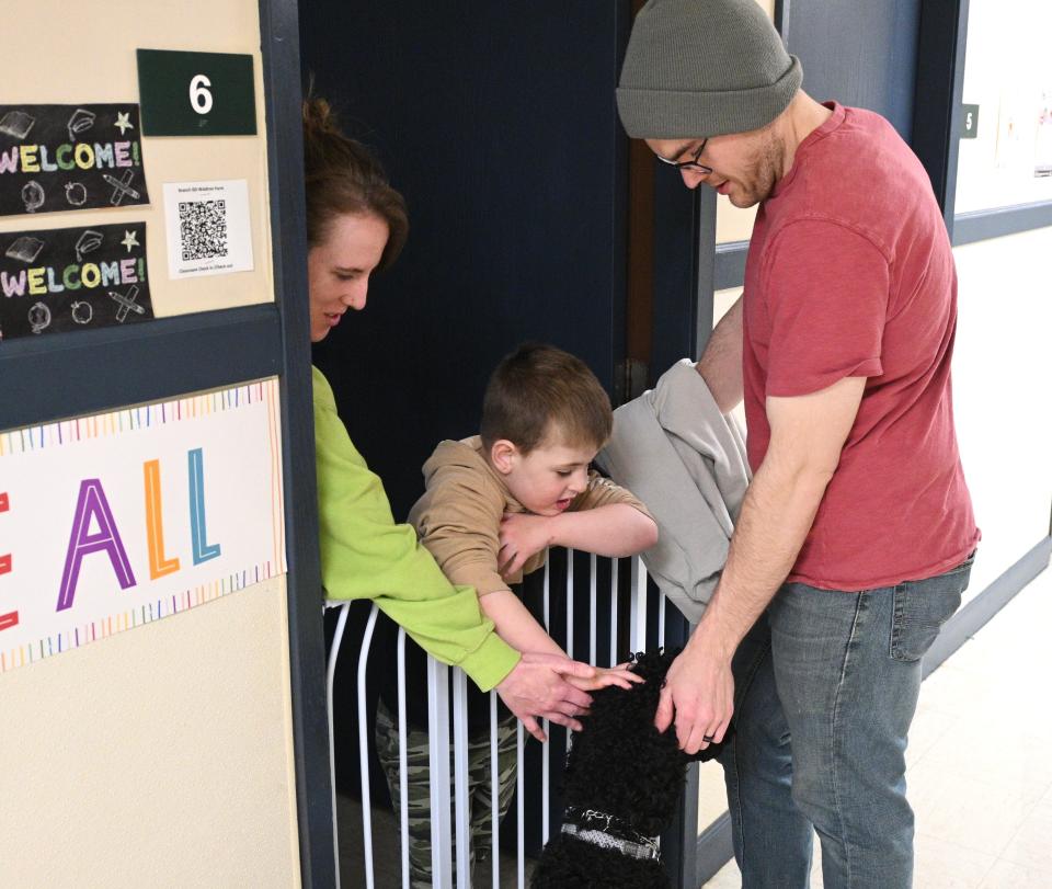 Beef with handler Nick Porter visits a student and teacher in the halls of the Waldron Center.