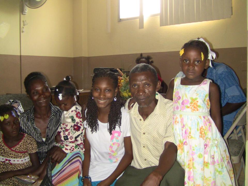 Jazmin Williamson, center, poses with her her birth parents and sisters, who live in Haiti. This photo was taken during a visit to Haiti in 2013. The young girls to the left of the photo are now 12 years old and 18 year old, and they are hoping to come to the United States through a new humanitarian program that launched in January.