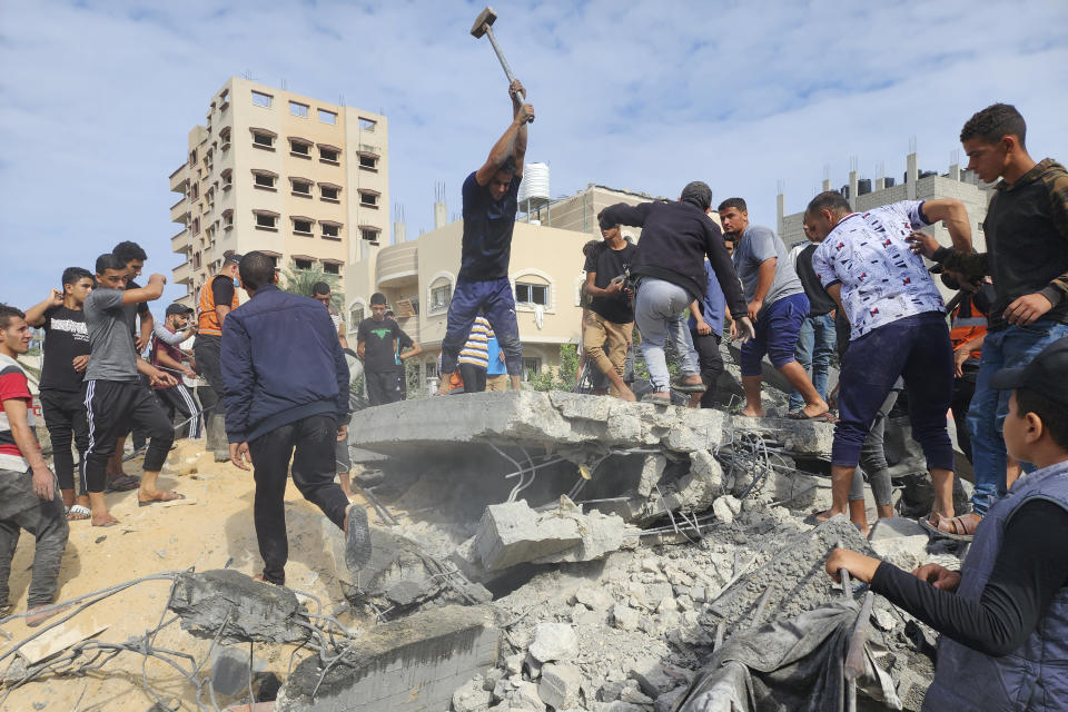 Palestinians look for survivors in buildings destroyed by Israeli airstrikes in Deir el-Balah, southern Gaza Strip, Tuesday, Oct. 17, 2023. (AP Photo/Hassan Eslaiah)