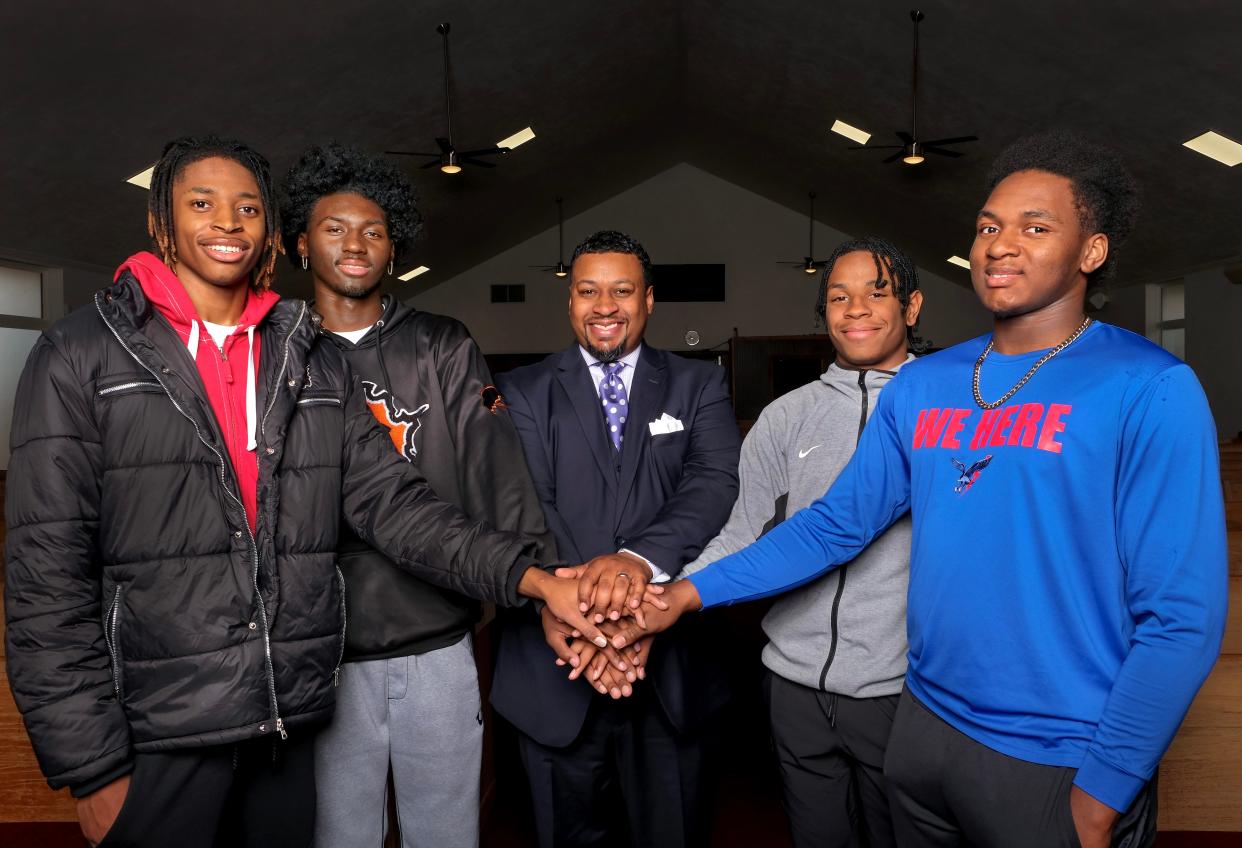 Gary Jones, center, minister of Eastside Church of Christ, poses for a photo with Douglass High School boy basketball team members Terry McMorris and Jace Breath, left, and Millwood High School boys basketball team members Will Mays and Carlos Strong, right. Jones' invited the players to his Oklahoma City church where the congregation donated $1,000 to each school to help pay for the teams' state championship rings.