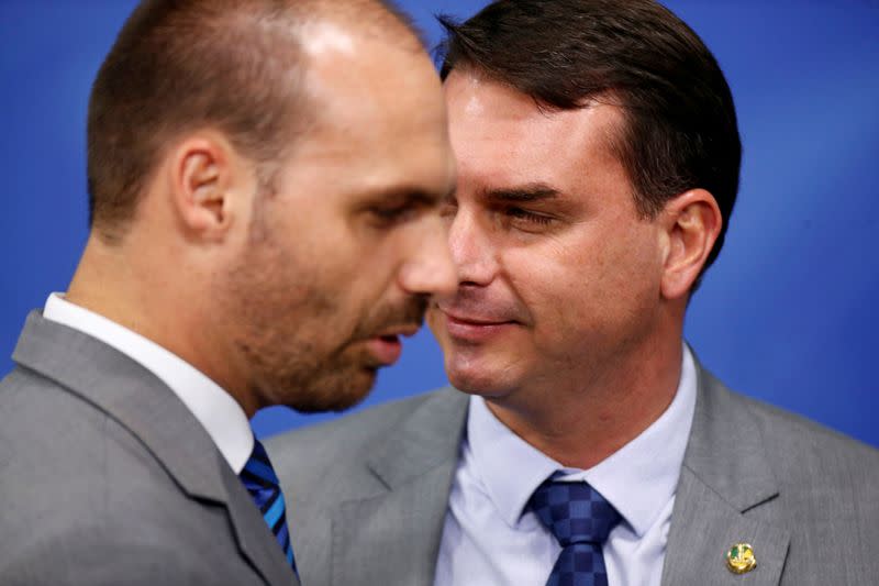 FILE PHOTO: Brazilian Federal Deputy Eduardo Bolsonaro stands near Senator Flavio Bolsonaro before a sanction ceremony of the new telecommunications Law at the Planalto Palace in Brasilia