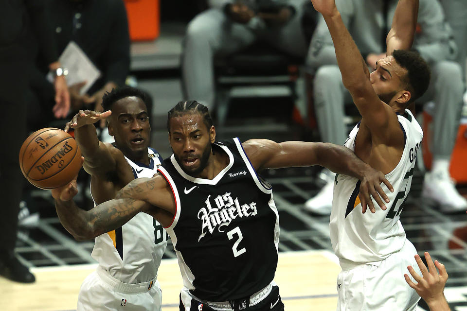 Kawhi Leonard #2 of the LA Clippers passes through the defense of Rudy Gobert #27 and Miye Oni #81 of the Utah Jazz during the first half of a game at Staples Center on June 12, 2021 in Los Angeles, California.  NOTE TO USER: User expressly acknowledges and agrees that, by downloading and or using this photograph, User is consenting to the terms and conditions of the Getty Images License Agreement.  (Photo by Sean M. Haffey/Getty Images)