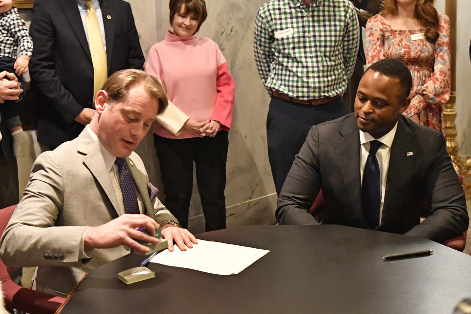 Kentucky Secretary of State Michael Adams, left, certifies the forms to officially accept the filing of Kentucky Attorney General David Cameron as a candidate for Governor in Frankfort, Ky., Tuesday, Jan. 3, 2023. (AP Photo/Timothy D. Easley)