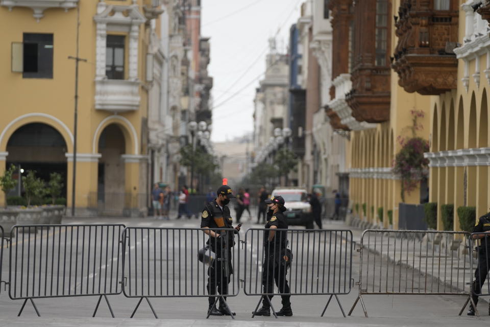 Police close a street near the government palace in Lima, Peru, early Thursday, Dec. 8, 2022. Peru's Congress voted to remove President Pedro Castillo from office Wednesday and replace him with the vice president, shortly after Castillo tried to dissolve the legislature ahead of a scheduled vote to remove him. (AP Photo/Fernando Vergara)