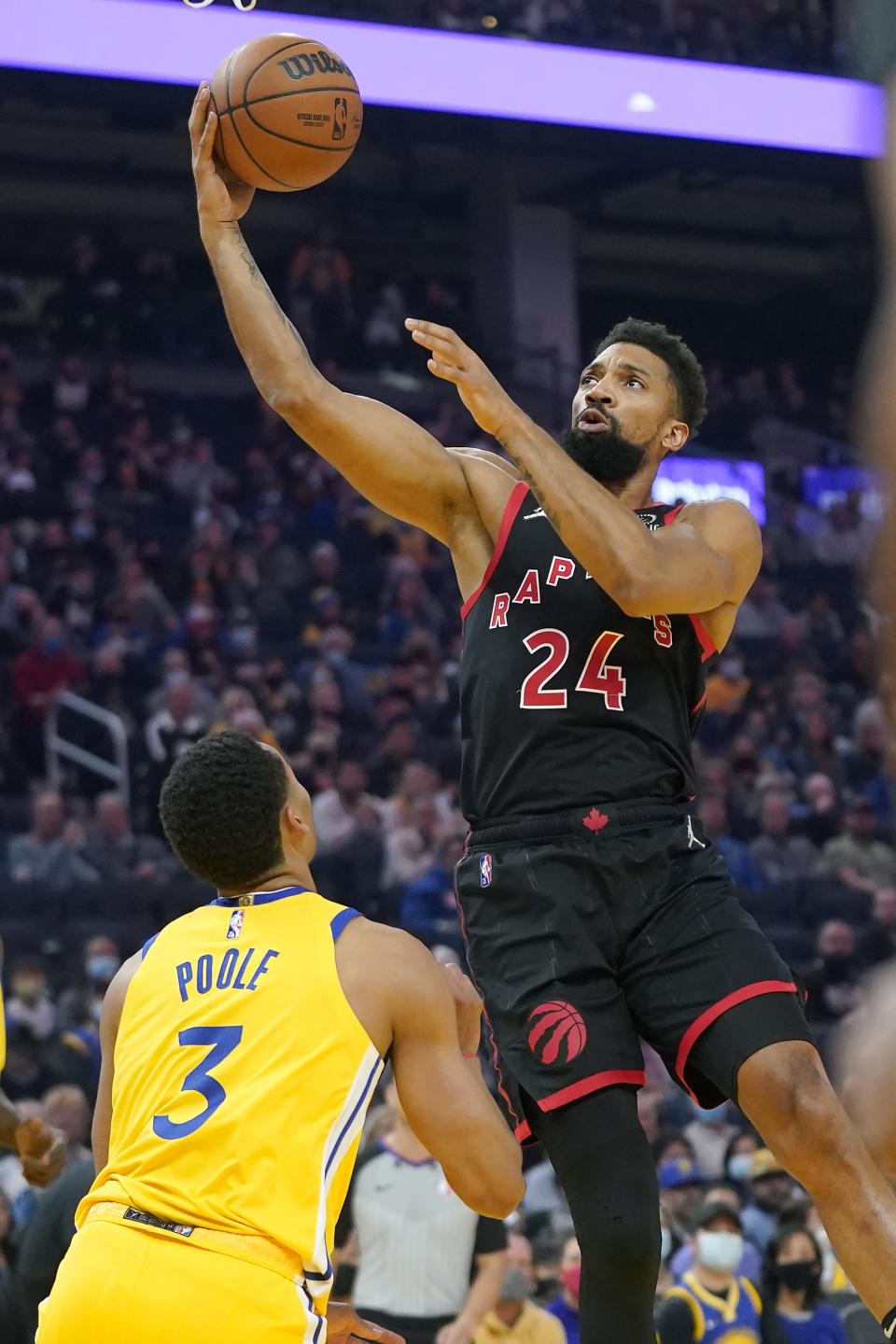 Toronto Raptors center Khem Birch (24) shoots over Golden State Warriors guard Jordan Poole (3) during the first half of an NBA basketball game in San Francisco, Sunday, Nov. 21, 2021. (AP Photo/Jeff Chiu)