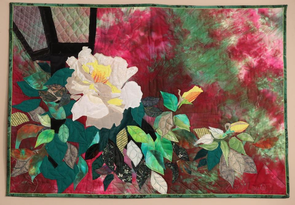 A floral quilt by Wendy Lewis hangs in her quilting room in her home in Green.