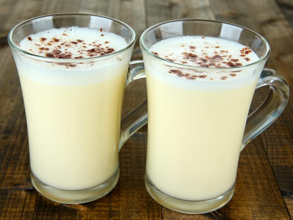 two glasses of eggnog on a wooden table