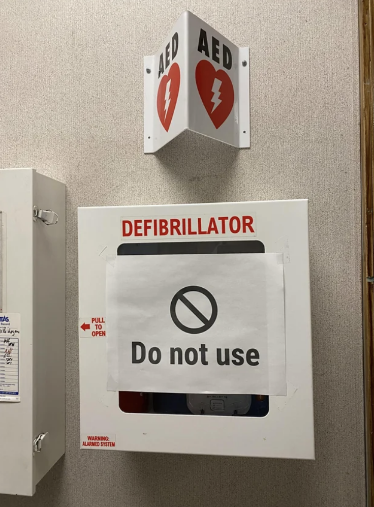 A case labeled defibrillator has a sign over it saying "do not use"